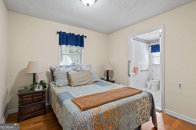 954 Bryant St SW, Conyers, GA 30012 - bedroom featuring wood finished floors, multiple windows, a textured ceiling, connected bathroom, and baseboards