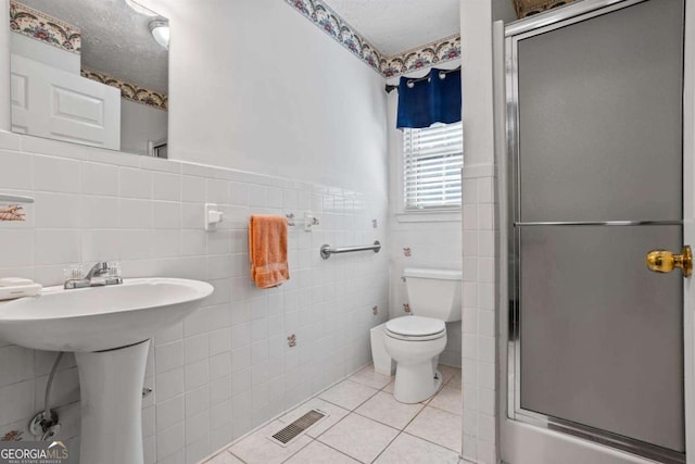 954 Bryant St SW, Conyers, GA 30012 - full bath with tile walls, a shower stall, toilet, tile patterned flooring, and wainscoting