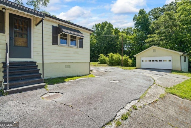 954 Bryant St SW, Conyers, GA 30012 - view of property exterior with entry steps, a detached garage, and an outdoor structure