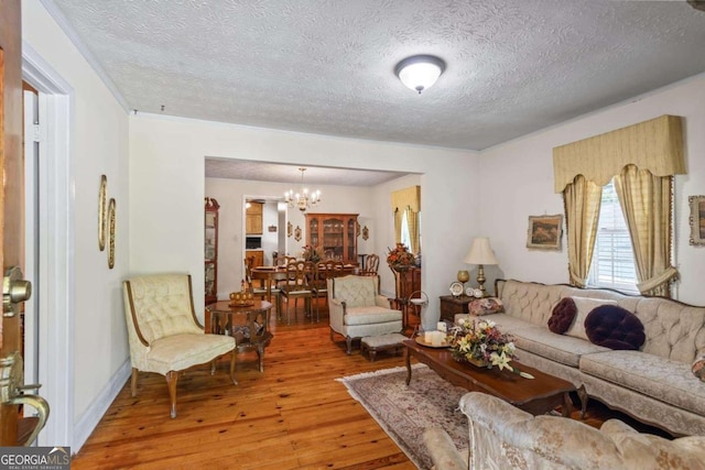 954 Bryant St SW, Conyers, GA 30012 - living area with light wood finished floors, a textured ceiling, a chandelier, and crown molding