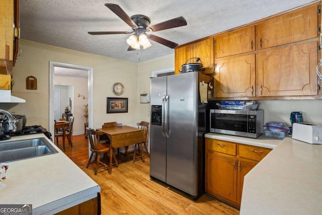 954 Bryant St SW, Conyers, GA 30012 - kitchen featuring stainless steel appliances, a textured ceiling, ceiling fan, light wood-style floors, and light countertops