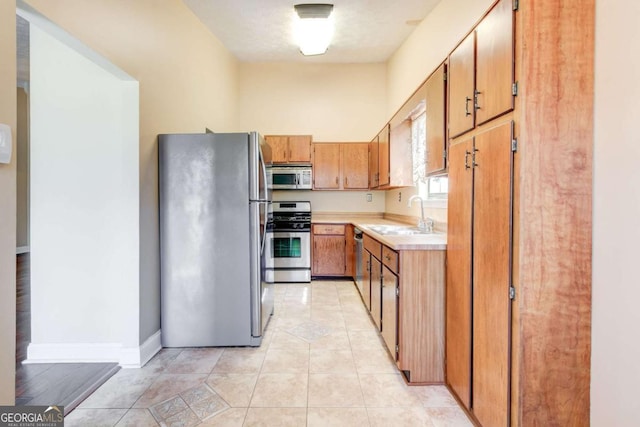 2211 Jonathan Ave, Lithonia, GA 30058 - kitchen featuring stainless steel appliances, light countertops, brown cabinets, and light tile patterned floors