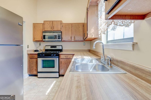 2211 Jonathan Ave, Lithonia, GA 30058 - kitchen featuring appliances with stainless steel finishes, light countertops, light tile patterned floors, and brown cabinets