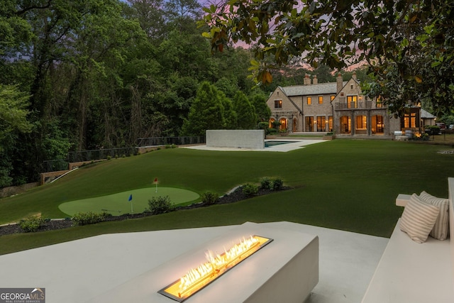 4560 Harris Trl, Atlanta, GA 30327 - view of yard featuring a putting green, a fire pit, a patio, a balcony, and an outdoor pool