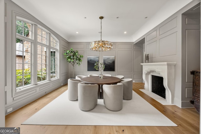 4560 Harris Trl, Atlanta, GA 30327 - dining area with a decorative wall, a chandelier, a fireplace with flush hearth, light wood-style floors, and recessed lighting