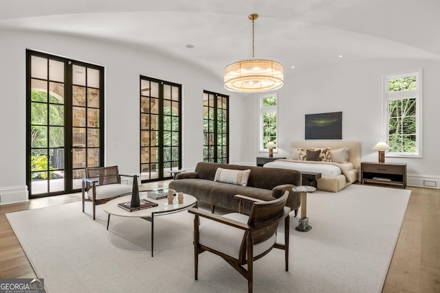 4560 Harris Trl, Atlanta, GA 30327 - bedroom featuring light wood finished floors, lofted ceiling, a chandelier, baseboards, and recessed lighting