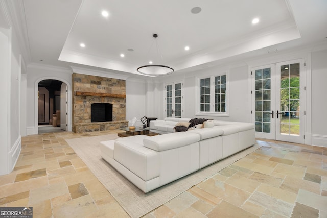 4560 Harris Trl, Atlanta, GA 30327 - living room featuring a tray ceiling, arched walkways, stone tile floors, crown molding, and french doors