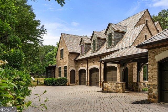 4560 Harris Trl, Atlanta, GA 30327 - view of property exterior with a high end roof, decorative driveway, and brick siding