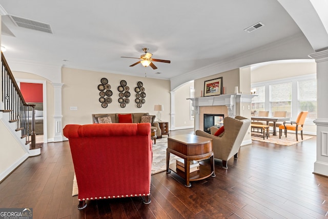 1516 Winward Dr, Locust Grove, GA 30248 - living room featuring decorative columns, ceiling fan, a glass covered fireplace, dark wood finished floors, and crown molding