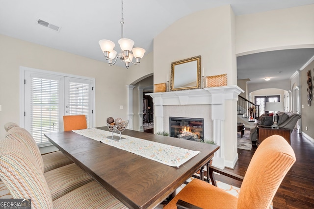 1516 Winward Dr, Locust Grove, GA 30248 - dining room with arched walkways, a glass covered fireplace, wood finished floors, a chandelier, and stairs