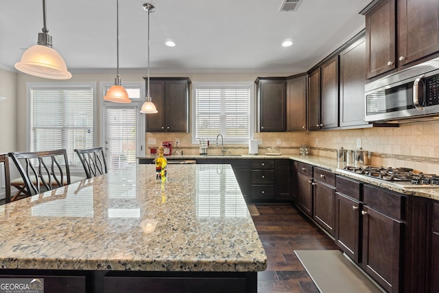 1516 Winward Dr, Locust Grove, GA 30248 - kitchen featuring stainless steel appliances, dark brown cabinets, a sink, light stone countertops, and recessed lighting
