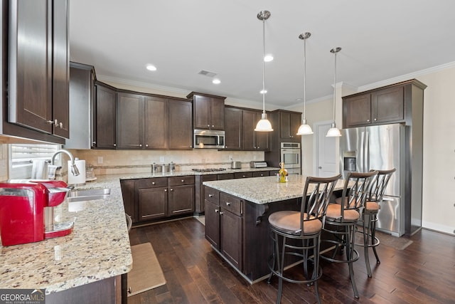1516 Winward Dr, Locust Grove, GA 30248 - kitchen with appliances with stainless steel finishes, dark brown cabinetry, ornamental molding, a center island, and a sink