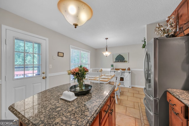2006 Carrollton Hwy, Temple, GA 30179 - kitchen with freestanding refrigerator, brown cabinetry, light tile patterned flooring, decorative light fixtures, and a center island