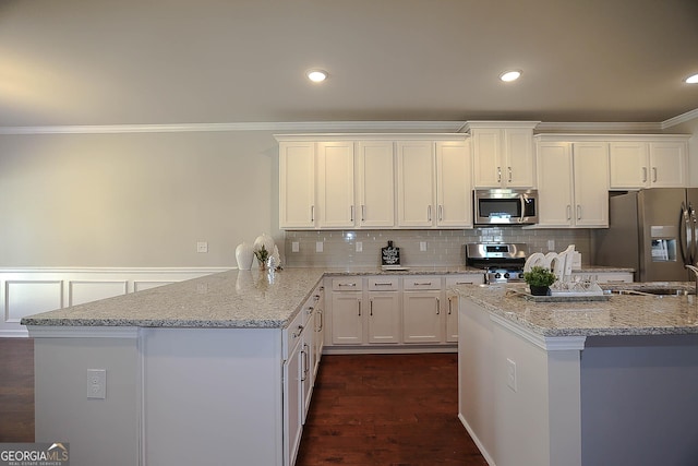 2304 Shetley Creek Dr, Norcross, GA 30071 - kitchen featuring stainless steel appliances, crown molding, a peninsula, light stone counters, and white cabinets