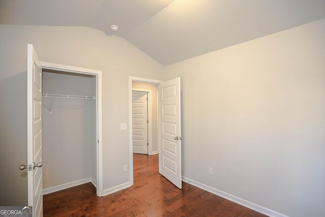 2304 Shetley Creek Dr, Norcross, GA 30071 - unfurnished bedroom featuring vaulted ceiling, dark wood-style flooring, a closet, and baseboards