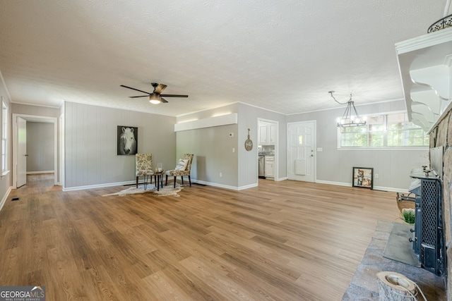 130 April Trce, Dawsonville, GA 30534 - unfurnished living room featuring ceiling fan, baseboards, light wood-style floors, crown molding, and a textured ceiling