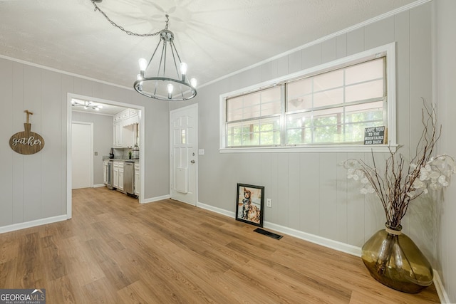 130 April Trce, Dawsonville, GA 30534 - unfurnished dining area featuring a chandelier, crown molding, light wood finished floors, baseboards, and a decorative wall
