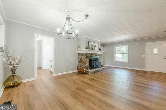 130 April Trce, Dawsonville, GA 30534 - unfurnished living room featuring a chandelier, crown molding, light wood-style floors, baseboards, and a textured ceiling
