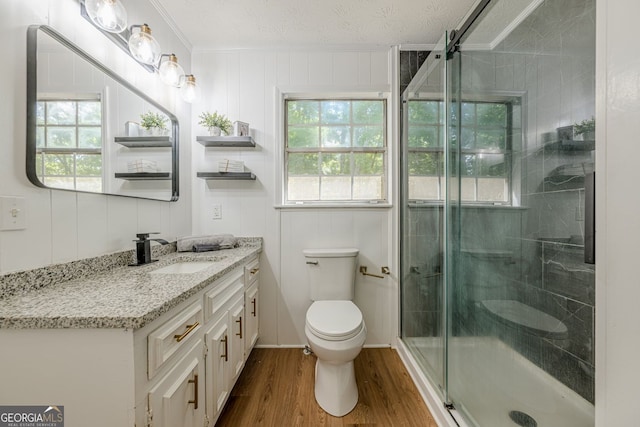 130 April Trce, Dawsonville, GA 30534 - bathroom featuring toilet, ornamental molding, vanity, wood finished floors, and a stall shower