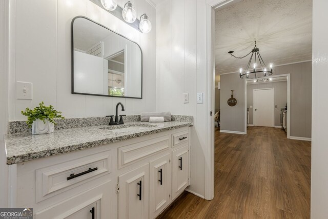 130 April Trce, Dawsonville, GA 30534 - bathroom featuring wood finished floors, vanity, a chandelier, ornamental molding, and baseboards