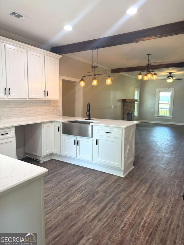 3 Thurman Dasher Rd, Reidsville, GA 30453 - kitchen featuring a sink, a peninsula, white cabinetry, hanging light fixtures, and beamed ceiling