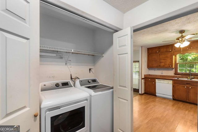 2617 Laurel Woods Ln SE, Conyers, GA 30094 - laundry area featuring separate washer and dryer, light wood finished floors, a ceiling fan, and a textured ceiling