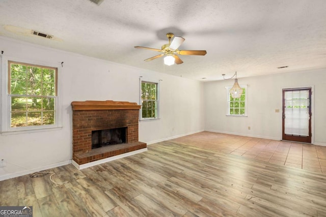 2617 Laurel Woods Ln SE, Conyers, GA 30094 - unfurnished living room with a textured ceiling, wood finished floors, healthy amount of natural light, and a ceiling fan