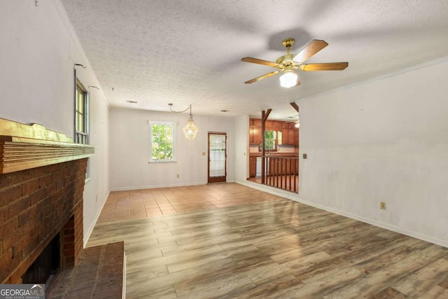 2617 Laurel Woods Ln SE, Conyers, GA 30094 - unfurnished living room with a textured ceiling, wood finished floors, a ceiling fan, a brick fireplace, and baseboards