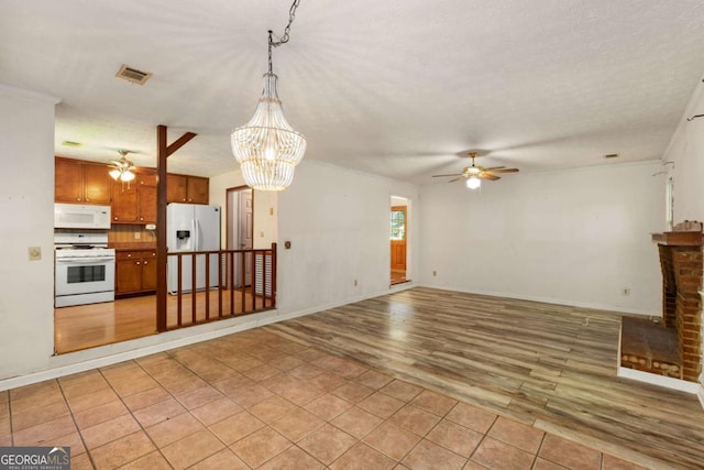 2617 Laurel Woods Ln SE, Conyers, GA 30094 - unfurnished living room featuring ceiling fan, light wood-style flooring, a chandelier, and baseboards