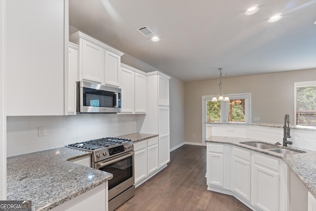 1537 Maplecliff Way, Sugar Hill, GA 30518 - kitchen with appliances with stainless steel finishes, a sink, white cabinetry, backsplash, and a chandelier