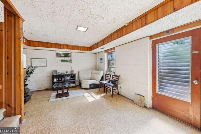 5222 Skyline Dr, Stone Mountain, GA 30083 - sitting room featuring concrete block wall and carpet flooring
