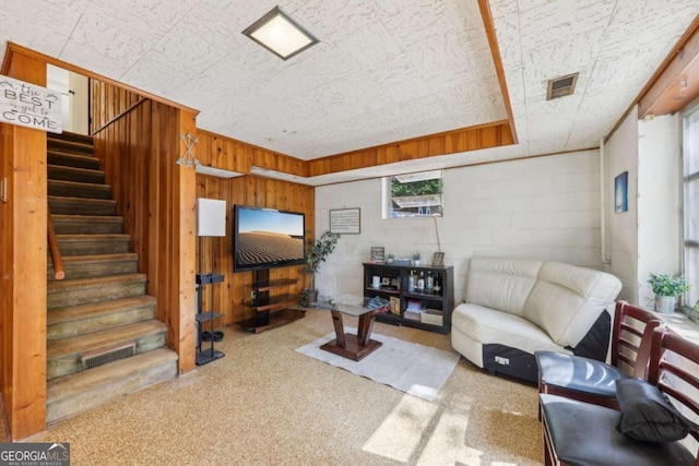 5222 Skyline Dr, Stone Mountain, GA 30083 - carpeted living area with stairway, wood walls, and concrete block wall