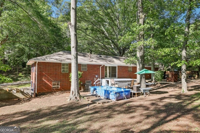 5222 Skyline Dr, Stone Mountain, GA 30083 - back of property with brick siding, roof with shingles, and a jacuzzi