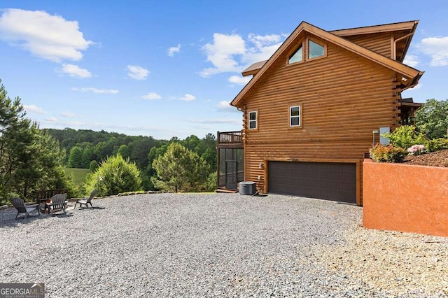 325 Emelia Dr, Morganton, GA 30560 - view of side of home with gravel driveway, an attached garage, log siding, and central AC unit