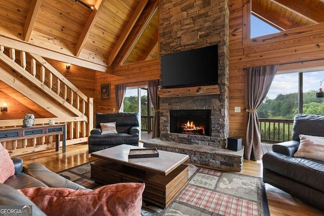 325 Emelia Dr, Morganton, GA 30560 - living room with wood walls, high vaulted ceiling, hardwood / wood-style floors, a stone fireplace, and wood ceiling with exposed beams