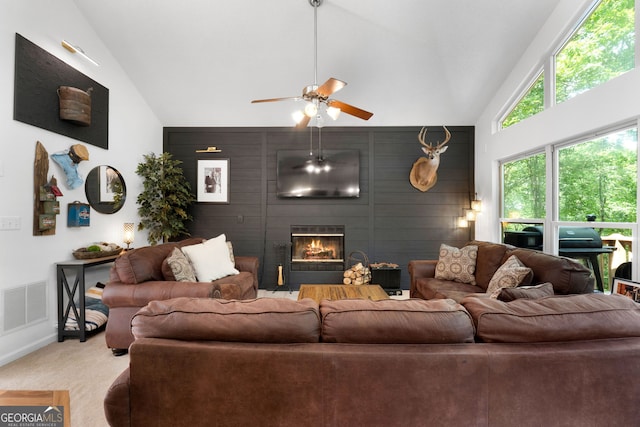 425 Wagers Mill Rd, Newnan, GA 30263 - carpeted living area featuring high vaulted ceiling, ceiling fan, an accent wall, a large fireplace, and baseboards