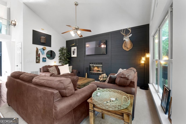 425 Wagers Mill Rd, Newnan, GA 30263 - living area featuring a large fireplace, an accent wall, ceiling fan, high vaulted ceiling, and light carpet