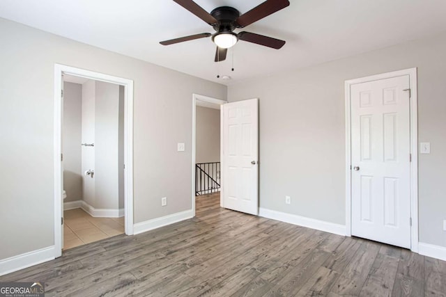 7 Villa Ct SE, Smyrna, GA 30080 - unfurnished bedroom featuring wood finished floors, baseboards, connected bathroom, and ceiling fan