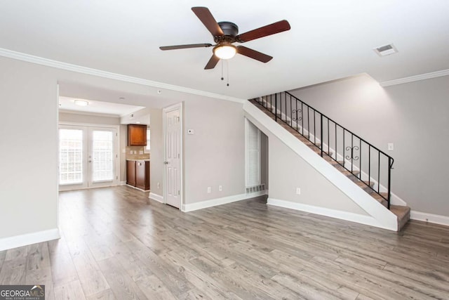 7 Villa Ct SE, Smyrna, GA 30080 - unfurnished living room featuring ornamental molding, stairway, a ceiling fan, light wood finished floors, and baseboards