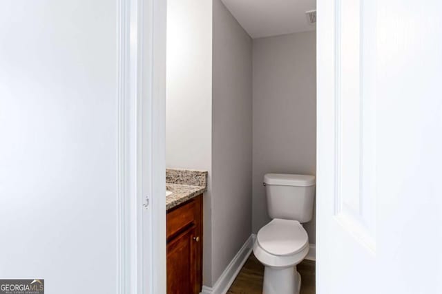 7 Villa Ct SE, Smyrna, GA 30080 - half bathroom featuring vanity, toilet, baseboards, and wood finished floors