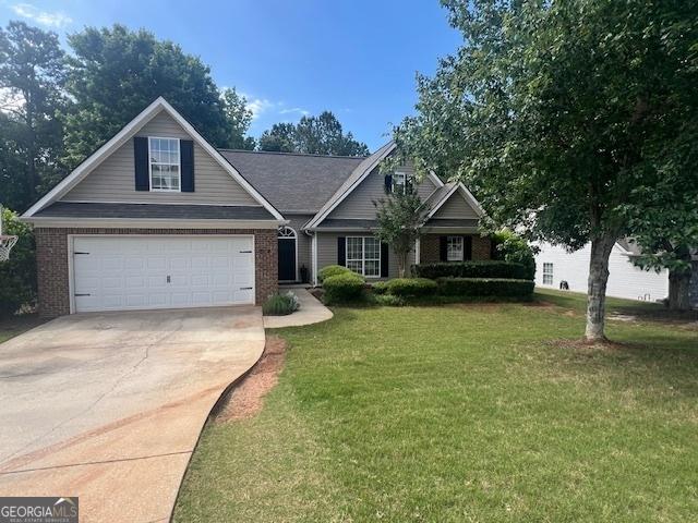 264 Baldwin Ct, Newnan, GA 30263 - view of front of house featuring concrete driveway, a front lawn, brick siding, and an attached garage