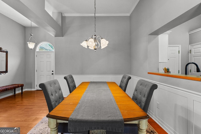 264 Baldwin Ct, Newnan, GA 30263 - dining space featuring a chandelier, wood finished floors, crown molding, and a wainscoted wall