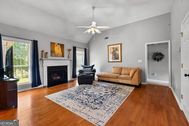 264 Baldwin Ct, Newnan, GA 30263 - living room with vaulted ceiling, a ceiling fan, a fireplace with flush hearth, and wood finished floors