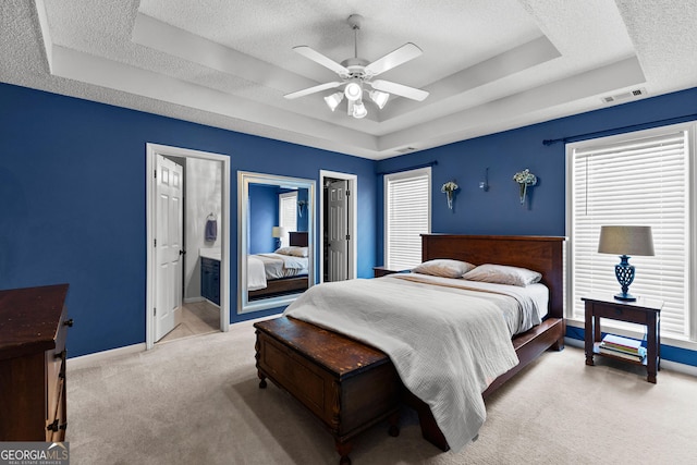 264 Baldwin Ct, Newnan, GA 30263 - carpeted bedroom featuring a tray ceiling, a textured ceiling, connected bathroom, and a ceiling fan