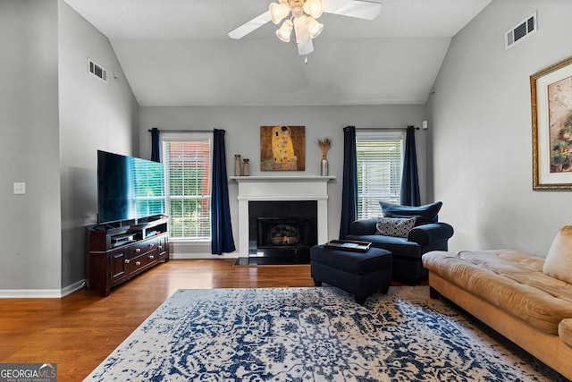 264 Baldwin Ct, Newnan, GA 30263 - living area featuring vaulted ceiling, wood finished floors, a ceiling fan, and a fireplace with flush hearth