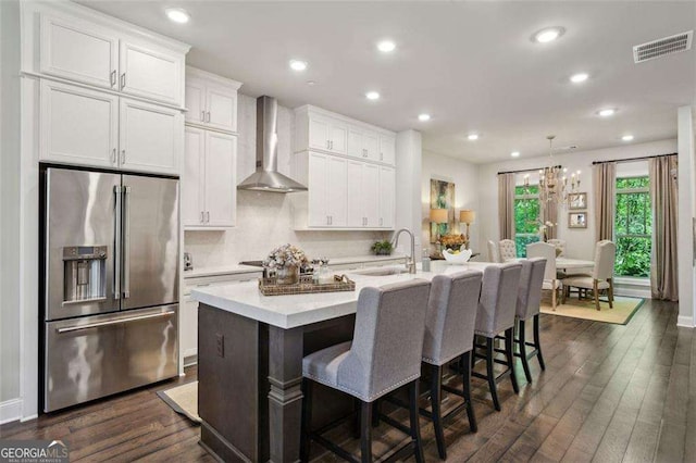4355 Parkside Pl, Sandy Springs, GA 30342 - kitchen featuring high end refrigerator, wall chimney exhaust hood, a sink, a center island with sink, and light countertops