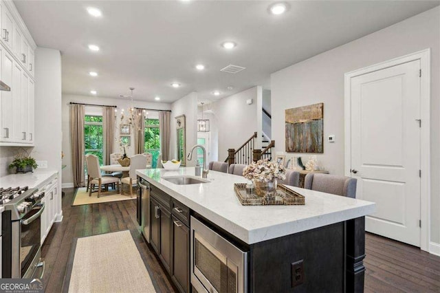 4355 Parkside Pl, Sandy Springs, GA 30342 - kitchen with stainless steel appliances, a sink, dark wood-style flooring, white cabinets, and a kitchen island with sink