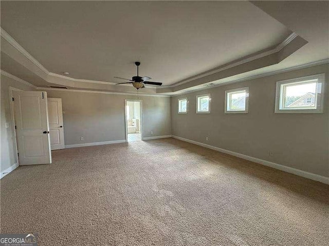 3488 Woodshade Dr, Loganville, GA 30052 - unfurnished room with a raised ceiling, crown molding, a ceiling fan, plenty of natural light, and light colored carpet