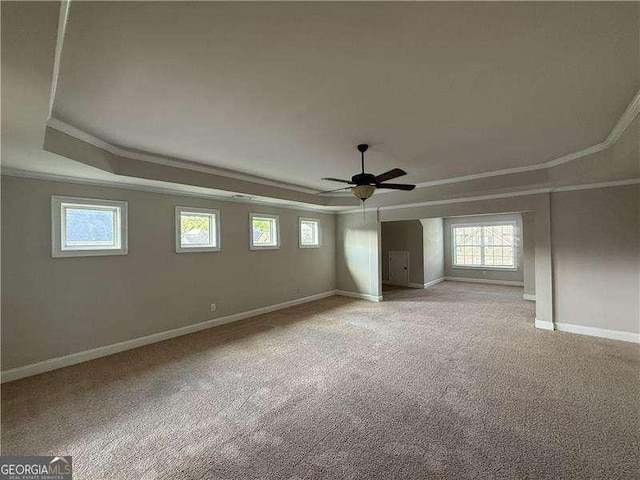 3488 Woodshade Dr, Loganville, GA 30052 - unfurnished bedroom featuring ornamental molding, a tray ceiling, baseboards, light carpet, and ceiling fan