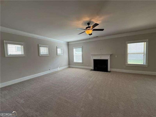 3488 Woodshade Dr, Loganville, GA 30052 - unfurnished living room featuring ornamental molding, baseboards, ceiling fan, light colored carpet, and a fireplace with flush hearth